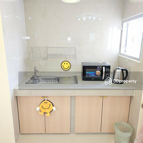 Kitchenette with microwave, kettle, sink, and dish rack.