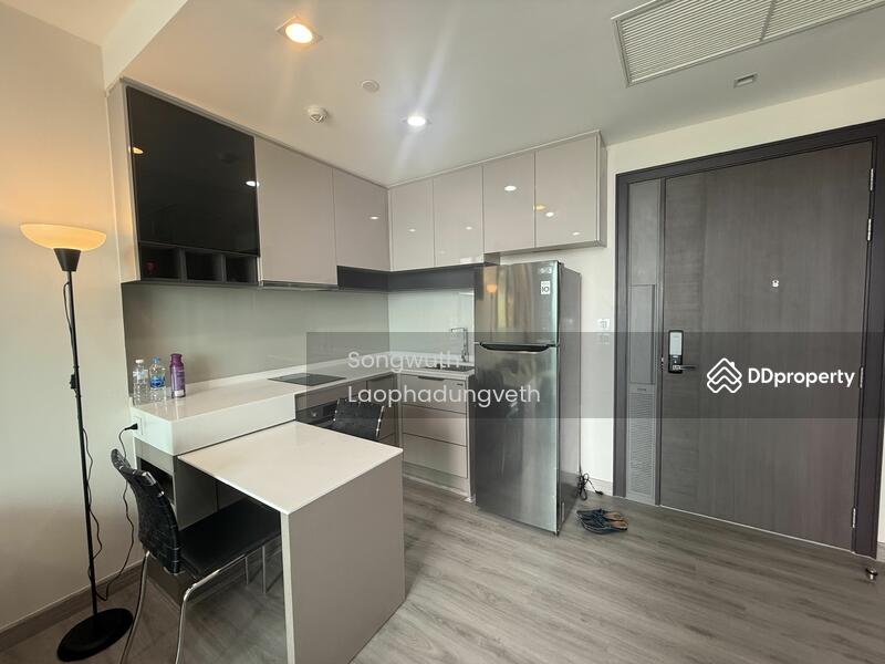 A built-in kitchen with oven ,electric stove  and cooker hood .